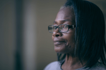Photo of Barbara Currin, a medium-dark-skinned mature Black woman with shoulder-length straight black hair. In this photo, she's wearing glasses.