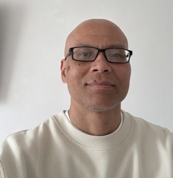 Photograph of Han, an Asian man with shaved head and glasses.